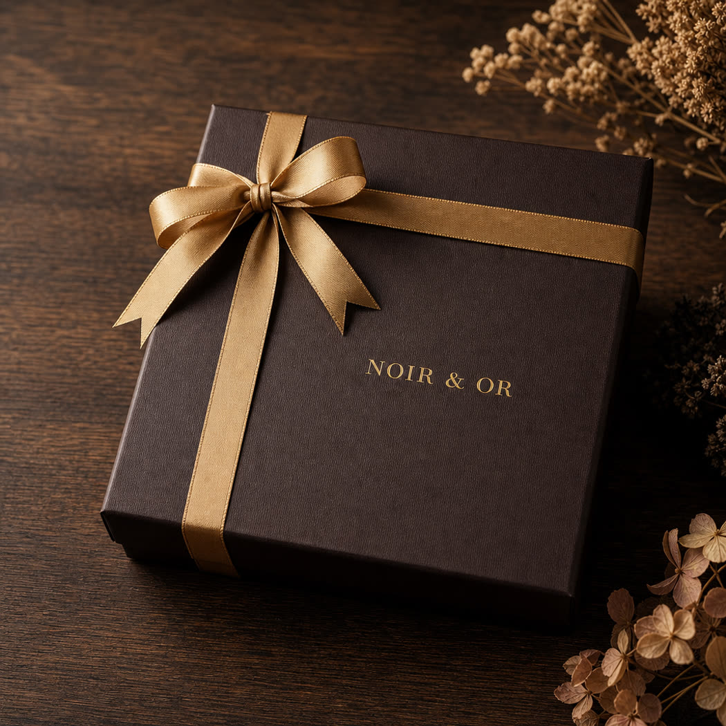 Rigid chocolate gift box tied closed with a gold ribbon