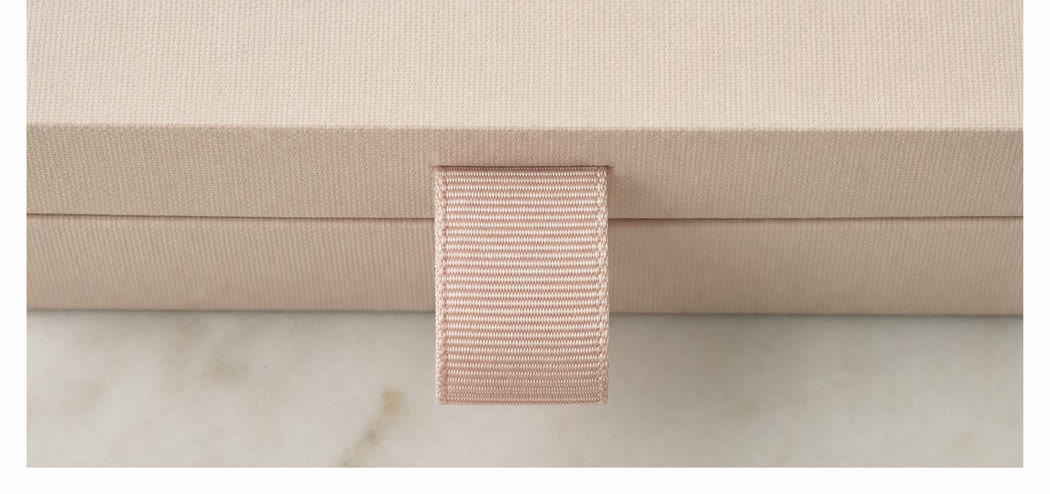 Macro detail of a ribbon pull on a cosmetics box