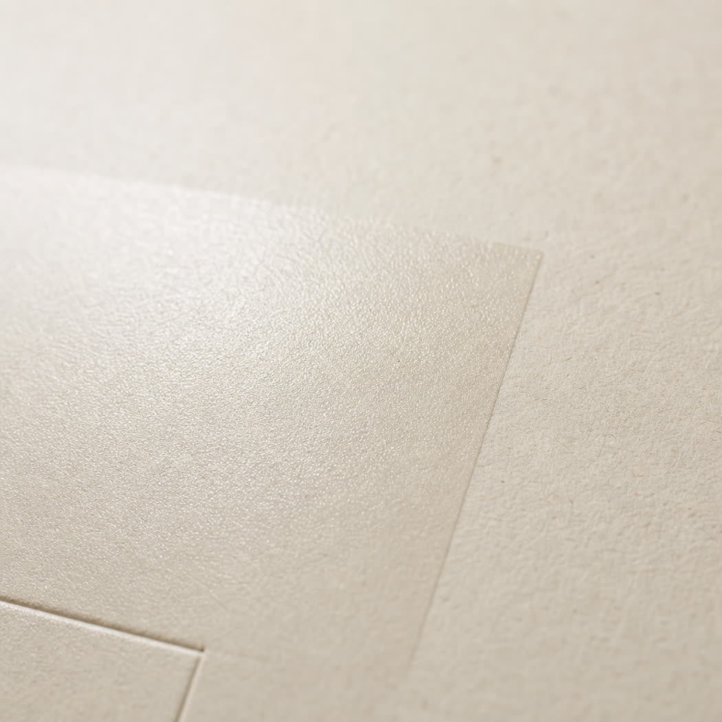 Macro detail of matte varnish coating on cream carton board